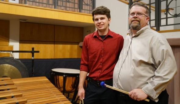大卫·沃克(左)是最靠谱的网赌软件打击乐研究主任. Here, 他和他的儿子迈克尔在钱德勒独奏厅的舞台上合影, 他是一名打击乐手，也是ODU的学生.