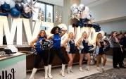 A group of cheerleaders in front of an ODU/EVMS sign. 